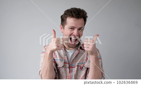 The European young man gives a thumbs up, approving the choice The European young man gives a thumbs up, approving the choice 102636869