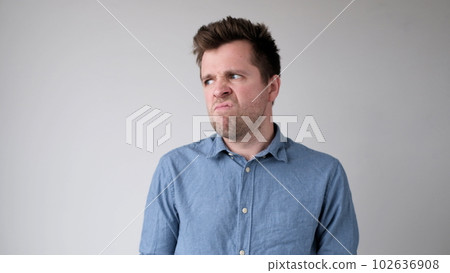 European young man is hesitating and unwilling to make decisions. He is upset about having to do unpleasant work. European young man is hesitating and unwilling to make decisions. He is upset about having to do unpleasant work. 102636908