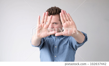 European young man shows a stop sign with his hands 102637442
