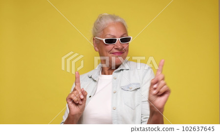Elderly European woman in sunglasses is dancing Elderly European woman in sunglasses is dancing 102637645