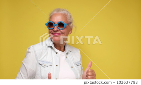 Elderly European woman in sunglasses is dancing 102637788
