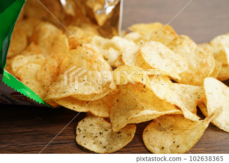 Potato chips in open bag, delicious BBQ seasoning spicy for crips, thin slice deep fried snack fast food in open bag. 102638365