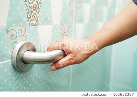 Asian woman patient use toilet support rail in bathroom, handrail safety grab bar, security in nursing hospital. Asian woman patient use toilet support rail in bathroom, handrail safety grab bar, security in nursing hospital. 102638397
