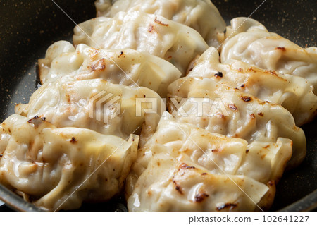 在煎鍋中重新加熱餃子。 在煎鍋中重新加熱餃子。 102641227