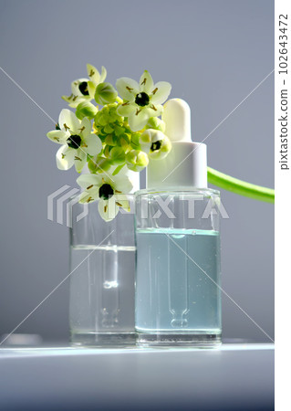 Two bottles with a dropper with spring flowers. Two bottles with a dropper with spring flowers. 102643472
