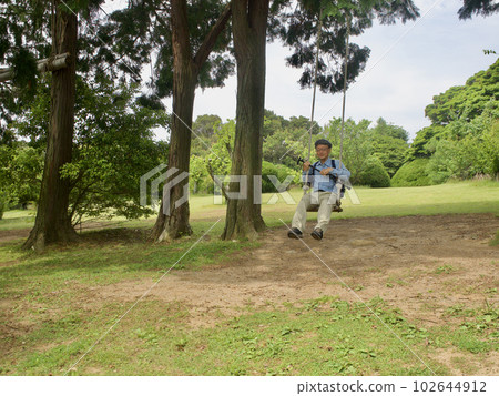在福岡縣能古島的森林裡盪鞦韆的老人 102644912