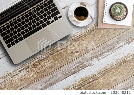 Laptop computer,blank notepad and coffee cup on wooden table 102648211