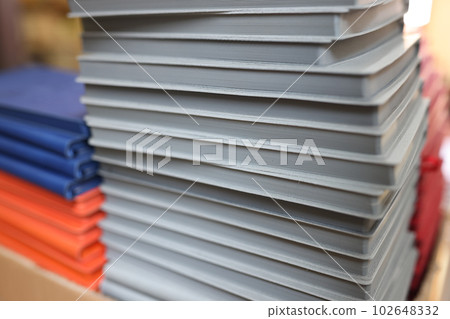 Stack of grey metallic notebooks on table in storage 102648332