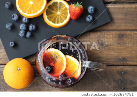 A glass pot filled with herbal tea with plenty of fresh fruit A glass pot filled with herbal tea with plenty of fresh fruit 102654791