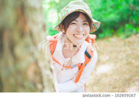 Smiling woman enjoying climbing with her head out from the shade 102659167