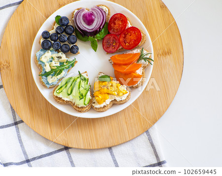 Rainbow sandwiches heart shape on white table 102659445