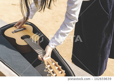 Musical instrument case Woman holding a guitar Musical instrument case Woman holding a guitar 102659639