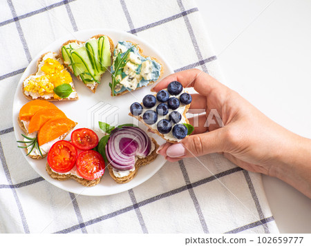 Rainbow sandwiches heart shape on white table 102659777