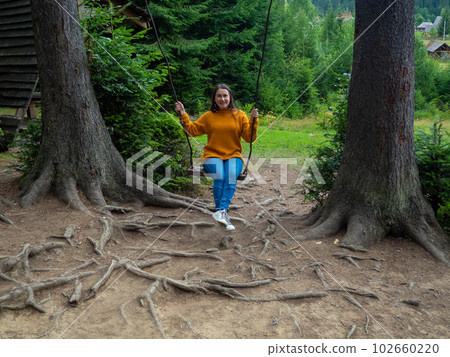 woman traveler enjoying of swinging on swing and mountain view 102660220
