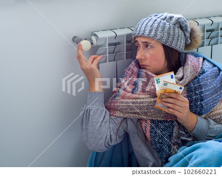 Woman sitting and counting euro banknotes near the battery 102660221