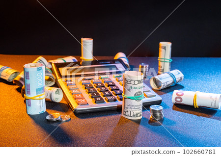 Banknotes, coins and calculator. Money and calculator on the table. 102660781