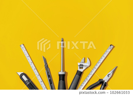 Flat lay composition with set of home repair tools on bright yellow background. Top view pattern with copy space. Flat lay composition with set of home repair tools on bright yellow background. Top view pattern with copy space. 102661033