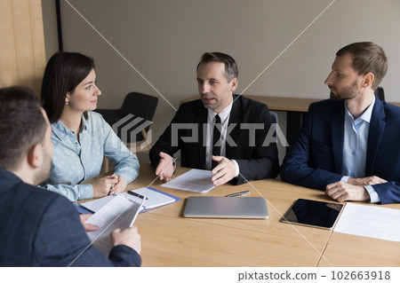 Confident mature businessman, boss talking to younger employees Confident mature businessman, boss talking to younger employees 102663918