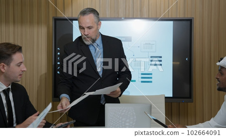 Business team meeting together talking and planing project paperwork Business team meeting together talking and planing project paperwork 102664091
