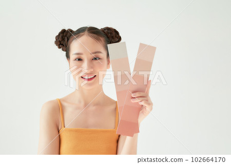 Asian beauty woman hold color scale with sun protection uv or sunscreen on the white background 102664170