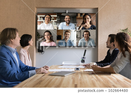 Multiethnic applicants on TV screen during group job interview event 102664480