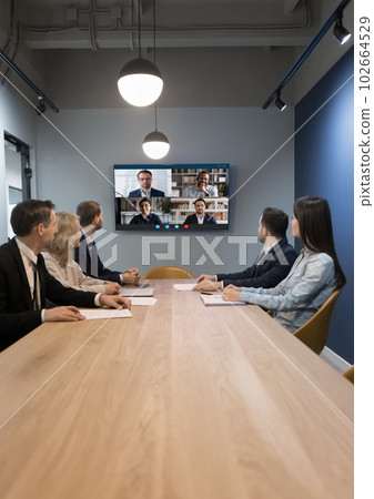 Team of businesspeople meeting at table in small conference room 102664529