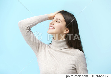 portrait of a beautiful young caucasian woman, head up, eyes closed, hand on forehead, 102665417