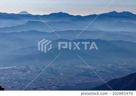 The Southern Alps and Mt. Fuji floating in the morning mist seen from the Hokendake ridgeline 102665470