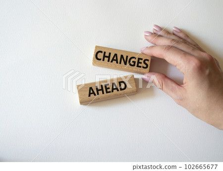 Changes ahead symbol. Wooden blocks with words Changes ahead. Businessman hand. Beautiful white background. Business and Changes ahead concept. Copy space. Changes ahead symbol. Wooden blocks with words Changes ahead. Businessman hand. Beautiful white background. Business and Changes ahead concept. Copy space. 102665677