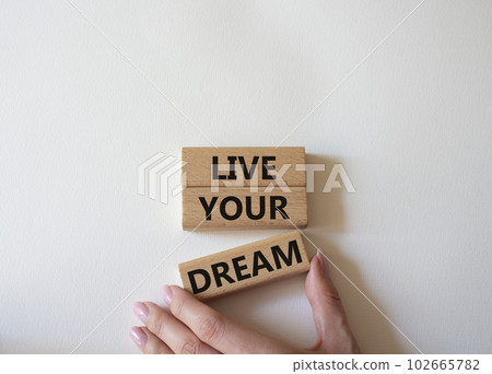 Live your Dream symbol. Wooden blocks with words Live your Dream. Beautiful white background. Businessman hand. Business and Live your Dream concept. Copy space. Live your Dream symbol. Wooden blocks with words Live your Dream. Beautiful white background. Businessman hand. Business and Live your Dream concept. Copy space. 102665782