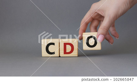 CDO - Collateralized Debt Obligation symbol. Wooden cubes with word CDO. Beautiful grey background. Businessman hand. Business and Collateralized Debt Obligation concept. Copy space. 102665847