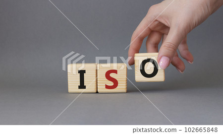 ISO standards quality control symbol. Concept word ISO on wooden cubes. Businessman hand. Beautiful grey background. Business and ISO concept. Copy space. ISO standards quality control symbol. Concept word ISO on wooden cubes. Businessman hand. Beautiful grey background. Business and ISO concept. Copy space. 102665848