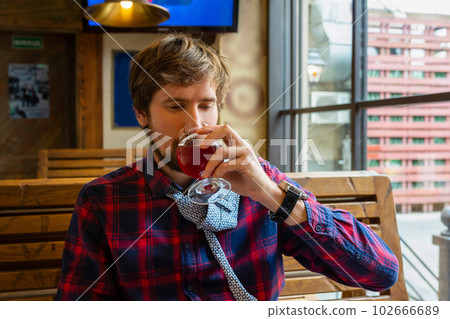 Young man drinking beer in a pub. A lonely young man with alcohol addiction problems. 102666689