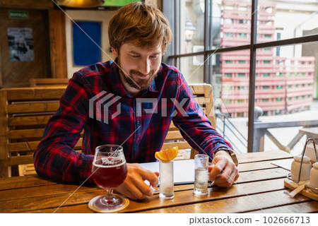 Happy man sits a bar alone. Alcoholism and the fight against alcohol addiction. Lifestyle 102666713