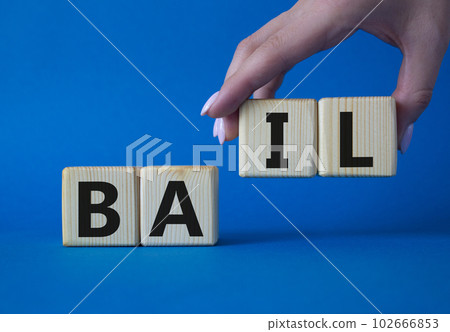 Bail symbol. Concept word Bail on wooden cubes. Businessman hand. Beautiful blue background. Business and Bail concept. Copy space. Bail symbol. Concept word Bail on wooden cubes. Businessman hand. Beautiful blue background. Business and Bail concept. Copy space. 102666853