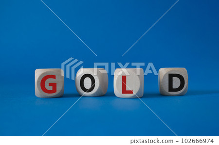 Gold symbol. Concept word Gold on wooden cubes. Beautiful blue background. Business and Gold concept. Copy space. Gold symbol. Concept word Gold on wooden cubes. Beautiful blue background. Business and Gold concept. Copy space. 102666974