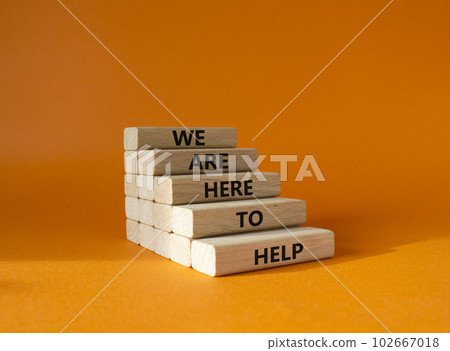 We are here to help symbol. Concept words we are here to help on wooden blocks. Beautiful orange background. Business and we are here to help concept. Copy space. We are here to help symbol. Concept words we are here to help on wooden blocks. Beautiful orange background. Business and we are here to help concept. Copy space. 102667018