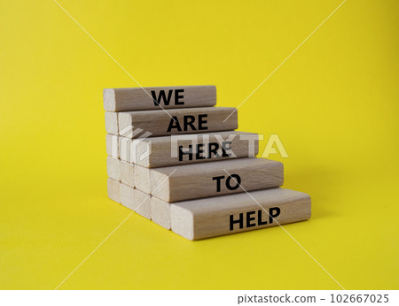 We are here to help symbol. Concept words we are here to help on wooden blocks. Beautiful yellow background. Business and we are here to help concept. Copy space. 102667025