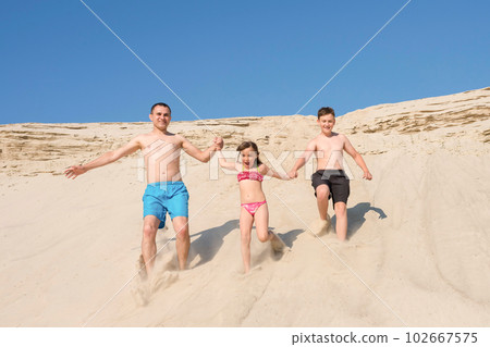 Happy family running on the beach sand, summer sea active vacation together. Family, joy, sport 102667575