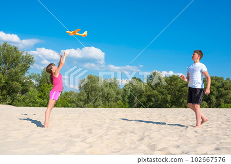 Happy children play on the beach on a sunny day. Beach games on vacation. Active lifestyle, rest 102667576