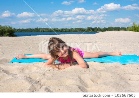 Happy girl is engaged in fitness outdoors on the shore of the beach. Happy girl is engaged in fitness outdoors on the shore of the beach. 102667605