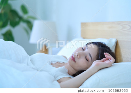 A young woman sleeping in bed 102668963