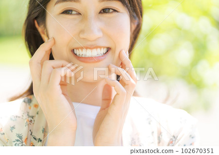 Image of a woman smiling in fresh green Image of a woman smiling in fresh green 102670351