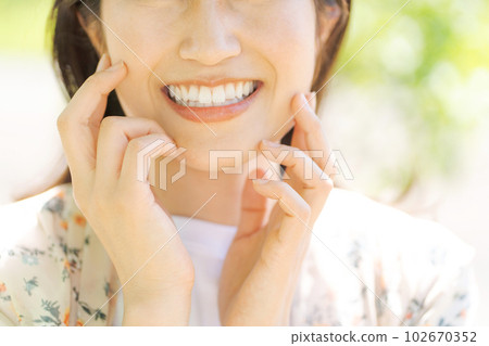 Image of a woman smiling in fresh green 102670352