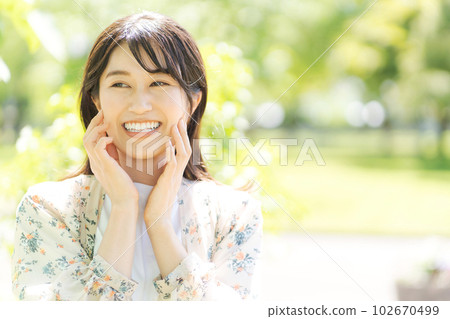 一個微笑的女人的形像在新鮮的綠色 102670499