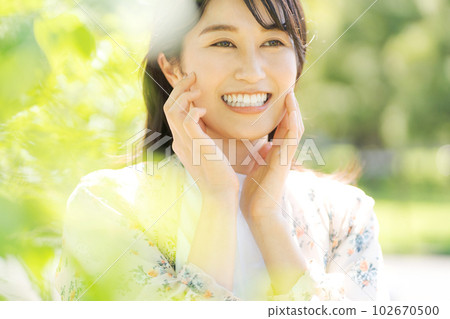一個微笑的女人的形像在新鮮的綠色 102670500
