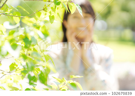 Photo of a woman smiling in the fresh green Photo of a woman smiling in the fresh green 102670839