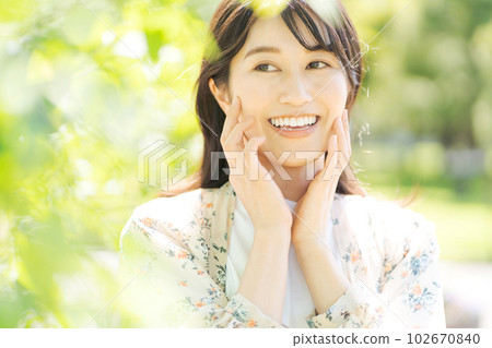 Photo of a woman smiling in the fresh green Photo of a woman smiling in the fresh green 102670840