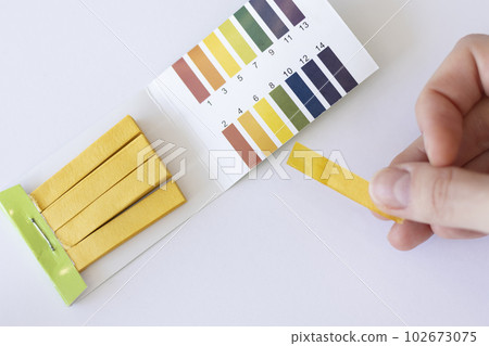 Water pH measurement test. Yellow strip in a woman's hand 102673075