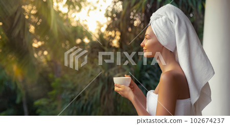 Woman With a Cup of Coffee After Shower on Open Resort Balcony Against Nature Background 102674237